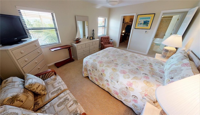 carpeted bedroom featuring multiple windows, ensuite bathroom, a spacious closet, and a closet