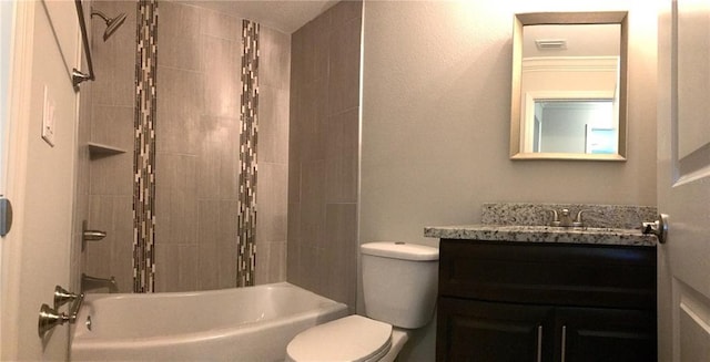 full bathroom with tiled shower / bath, toilet, and vanity with extensive cabinet space