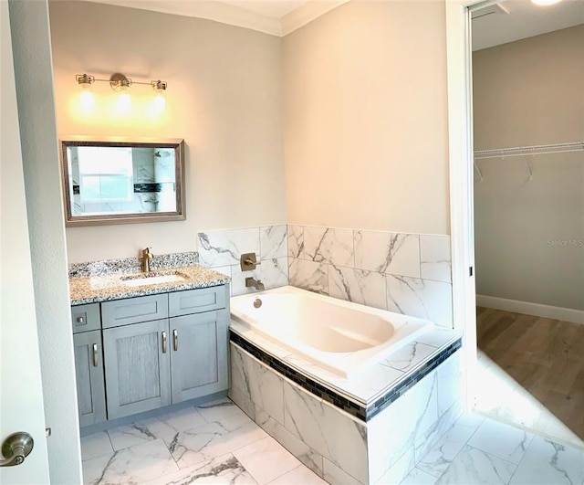 bathroom featuring tile floors, oversized vanity, crown molding, and tiled bath