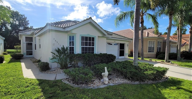 single story home with a garage and a front lawn