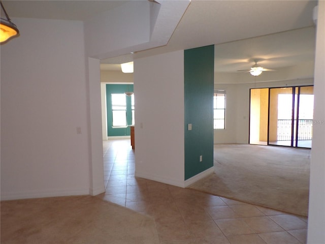 unfurnished room featuring light tile floors, ceiling fan, and a wealth of natural light