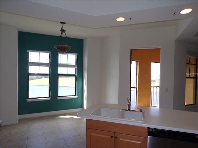 kitchen with sink, dishwasher, light tile flooring, decorative light fixtures, and light brown cabinets