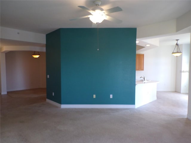 spare room with light colored carpet, ceiling fan, and sink