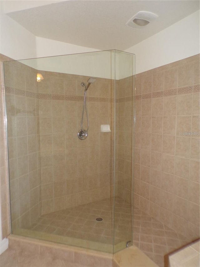 bathroom with an enclosed shower and tile floors