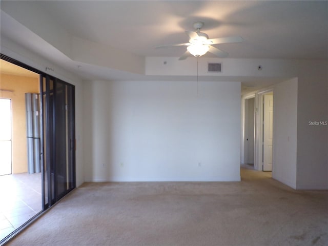 spare room featuring light carpet and ceiling fan