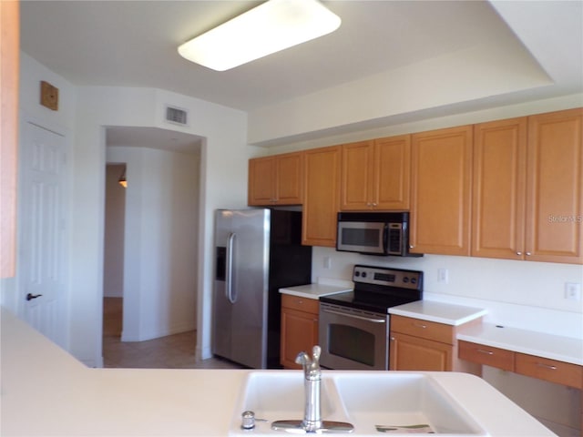 kitchen with light tile flooring, appliances with stainless steel finishes, and sink