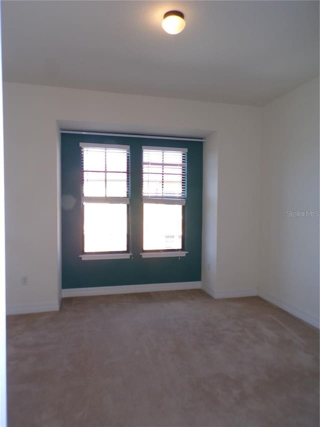 spare room with dark colored carpet