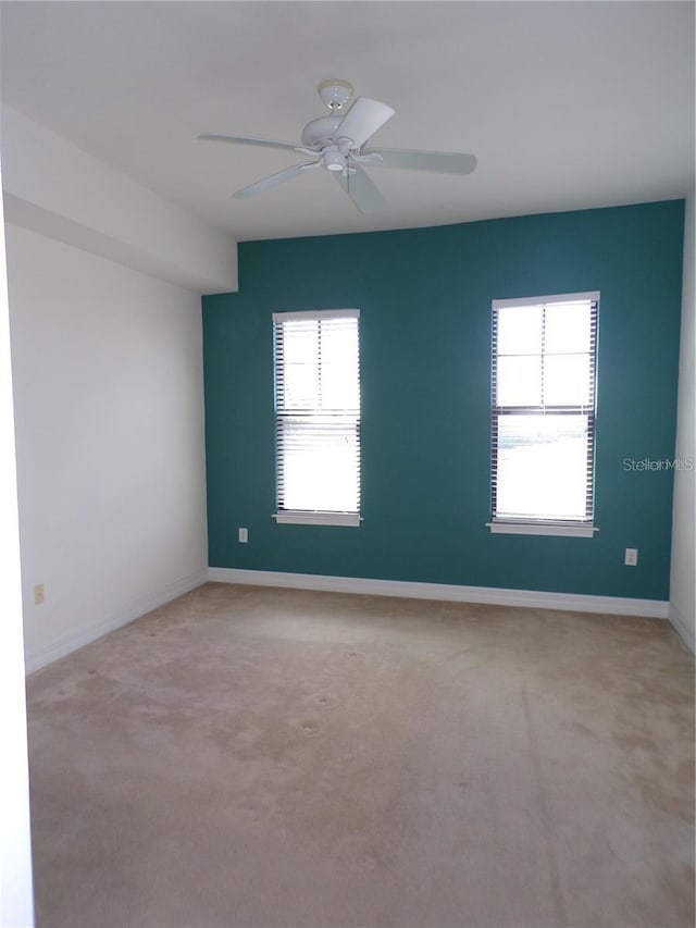 empty room featuring light colored carpet and ceiling fan