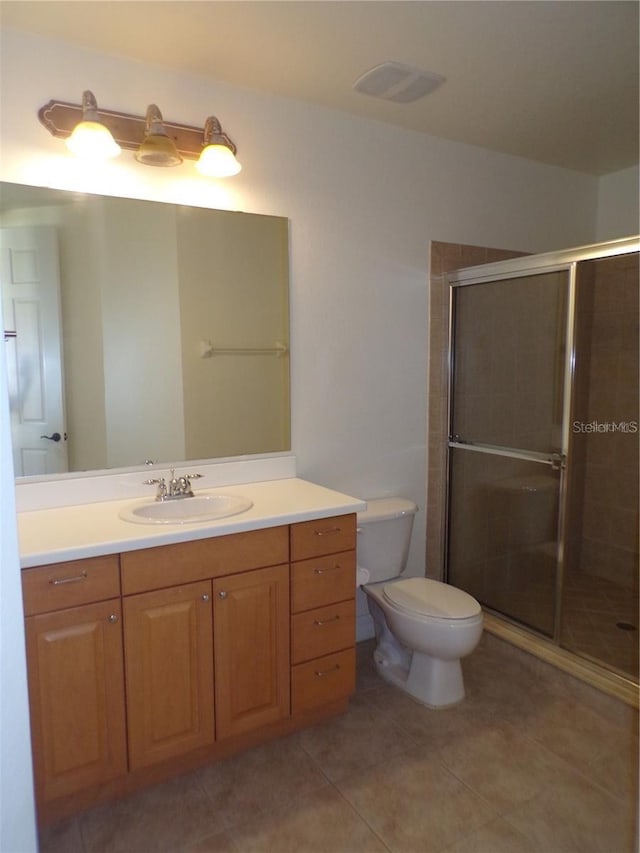 bathroom with an enclosed shower, vanity, tile flooring, and toilet