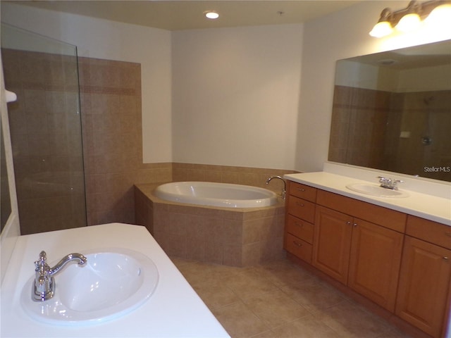 bathroom featuring tiled bath, tile floors, and vanity