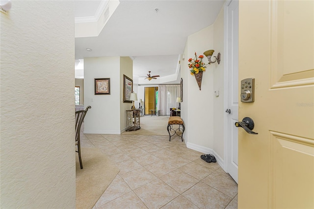 tiled foyer entrance featuring ceiling fan and ornamental molding