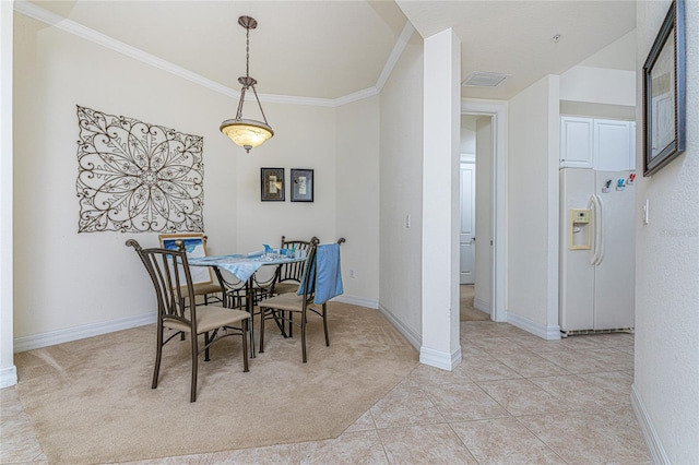 dining space featuring light tile floors and ornamental molding