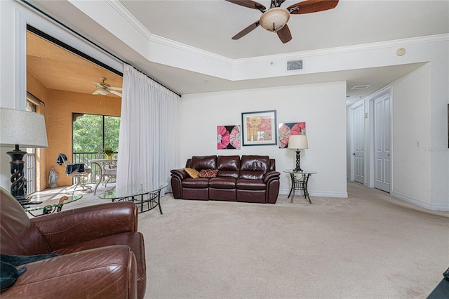 carpeted living room with ceiling fan and ornamental molding