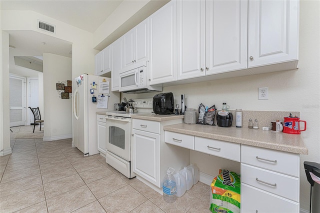 kitchen featuring white appliances, white cabinets, and light tile flooring