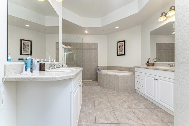 bathroom featuring tiled bath, tile flooring, and oversized vanity