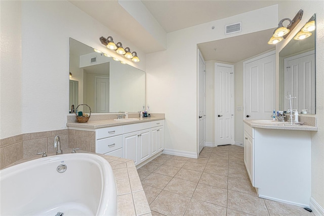 bathroom featuring tile floors, dual bowl vanity, and tiled bath