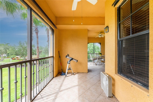 unfurnished sunroom with ceiling fan