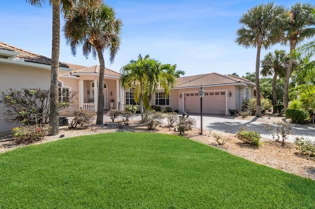 mediterranean / spanish-style home featuring a front lawn and a garage