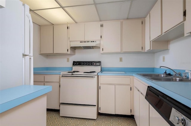 kitchen with white cabinetry, light tile flooring, white appliances, sink, and wall chimney range hood