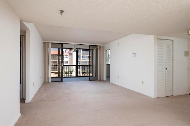 carpeted empty room featuring a textured ceiling and ceiling fan