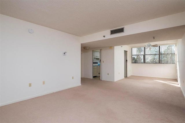 unfurnished room with light carpet, a textured ceiling, and ceiling fan