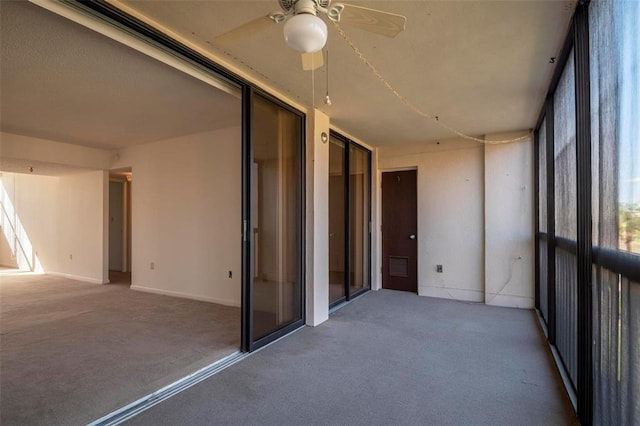 unfurnished sunroom featuring ceiling fan