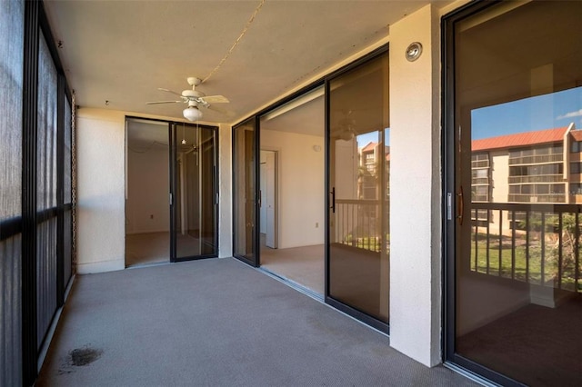 unfurnished sunroom featuring ceiling fan