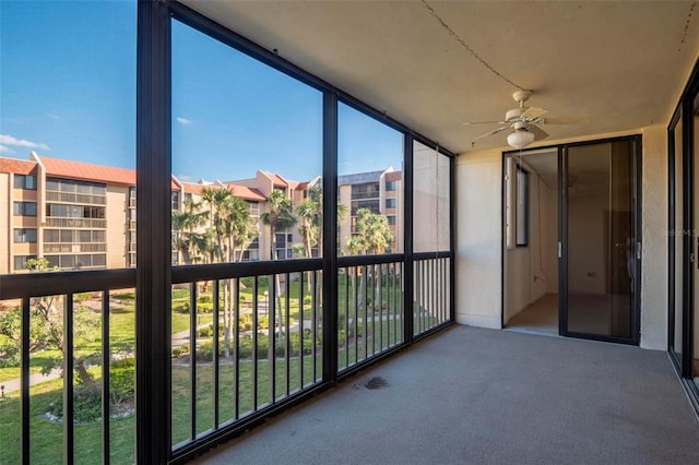 unfurnished sunroom with ceiling fan