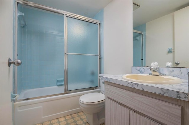 full bathroom with tile flooring, bath / shower combo with glass door, oversized vanity, and toilet