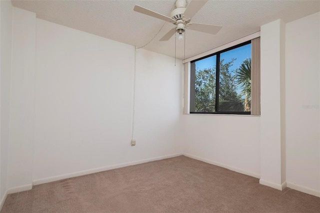 carpeted spare room featuring a textured ceiling and ceiling fan