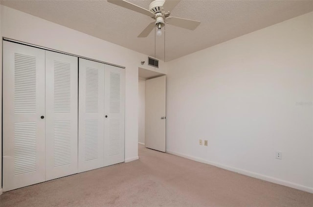 unfurnished bedroom featuring light colored carpet, a closet, and ceiling fan