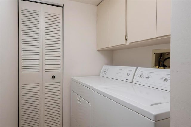 clothes washing area with washer hookup, cabinets, and washer and dryer