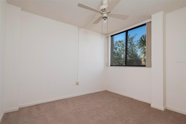3006 Caring Way Unit 325, Port Charlotte, FL 33952 - spare room featuring light carpet, ceiling fan, baseboards, and a textured ceiling