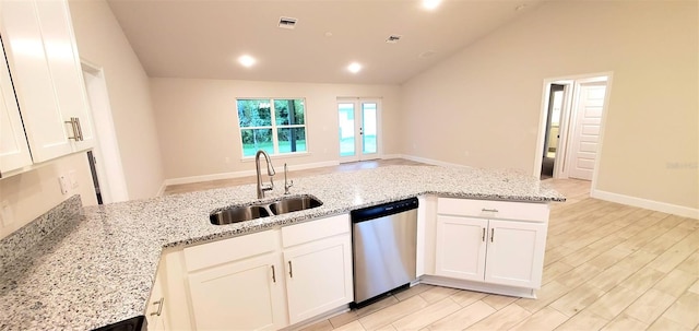 kitchen featuring light stone counters, stainless steel dishwasher, white cabinetry, and sink