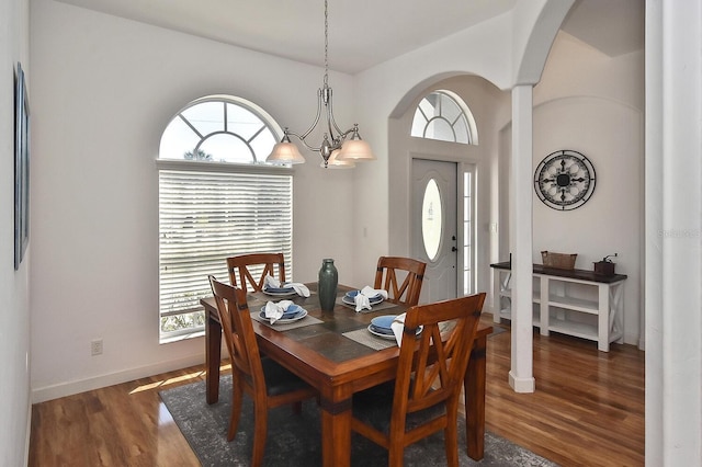 dining room with an inviting chandelier, plenty of natural light, and dark wood-type flooring