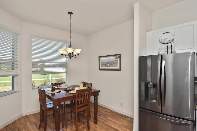 dining area with an inviting chandelier and wood-type flooring