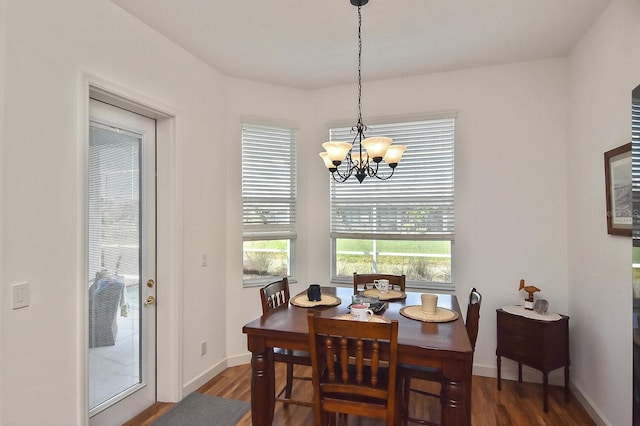 dining area featuring an inviting chandelier and dark wood-type flooring