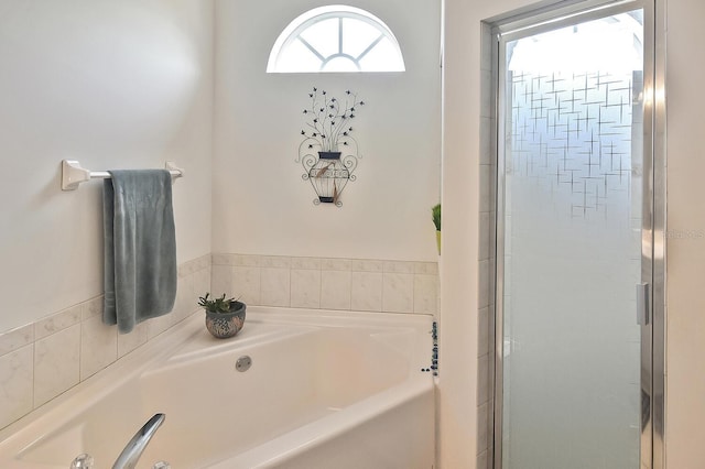 bathroom featuring shower with separate bathtub