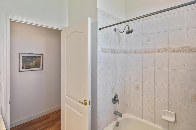 bathroom with hardwood / wood-style flooring and tiled shower / bath