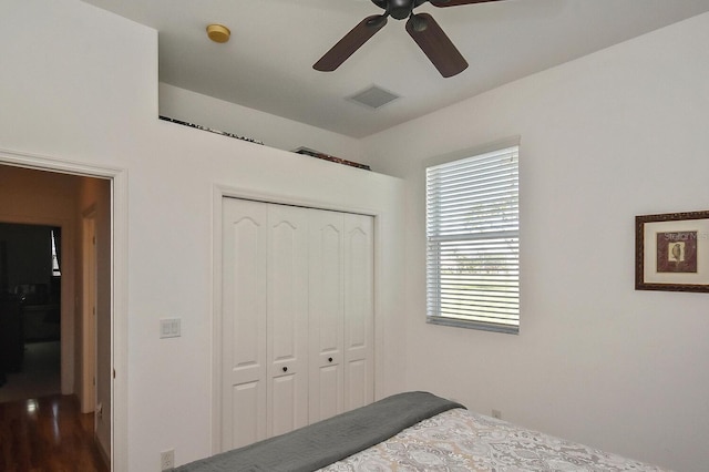 bedroom featuring a closet, dark hardwood / wood-style floors, and ceiling fan