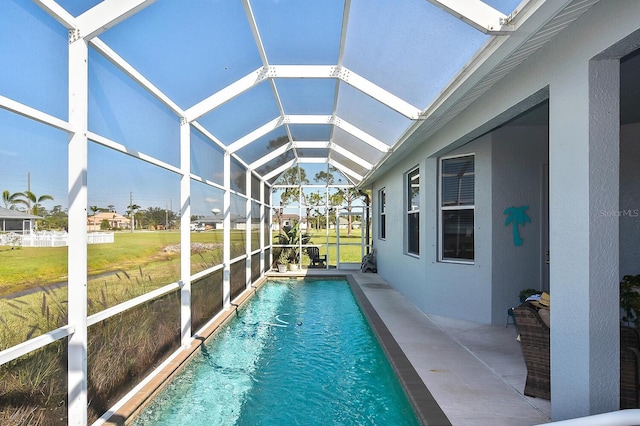 view of pool with a lanai, a lawn, and a patio