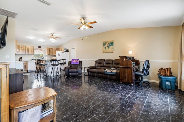 living room featuring vaulted ceiling, dark tile floors, and ceiling fan