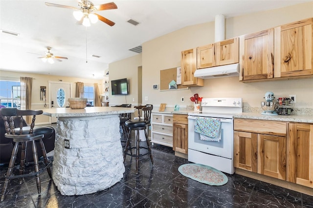 kitchen with dark tile floors, white electric stove, ceiling fan, and a breakfast bar area