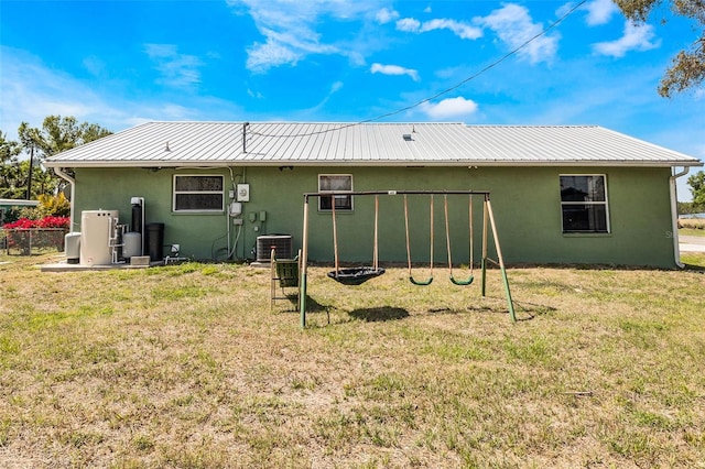 rear view of house featuring a yard and central AC