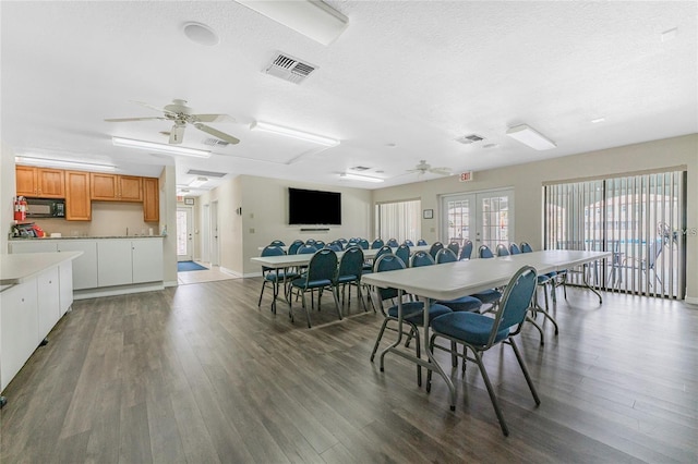 dining room featuring french doors, a textured ceiling, ceiling fan, and dark wood-type flooring