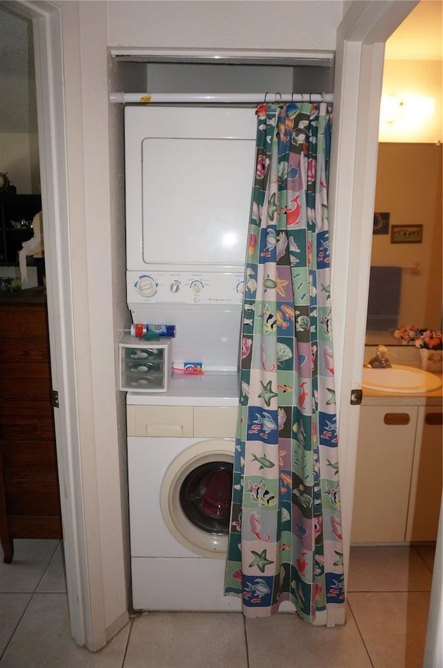 laundry room with light tile floors, stacked washer and clothes dryer, and sink