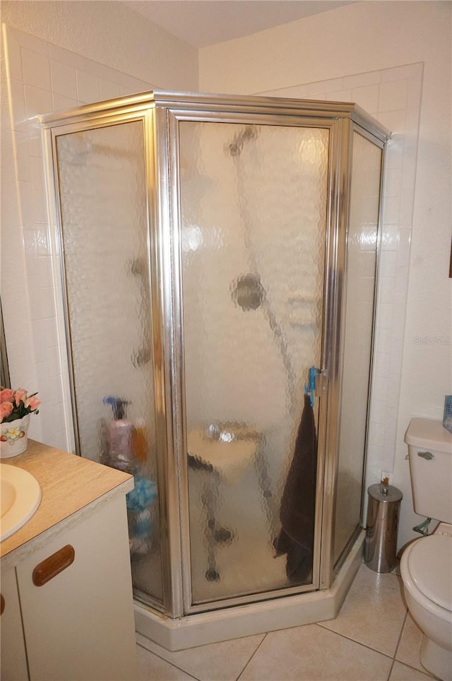 bathroom featuring toilet, tile flooring, walk in shower, and vanity