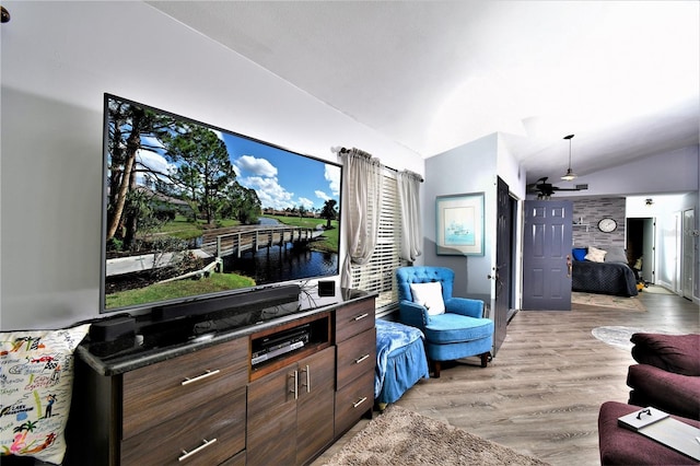 living room featuring light hardwood / wood-style flooring, ceiling fan, a wealth of natural light, and lofted ceiling