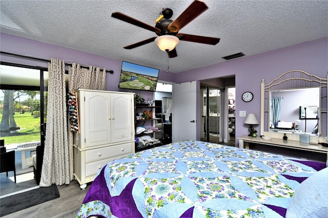 bedroom with a textured ceiling, ceiling fan, and light hardwood / wood-style flooring