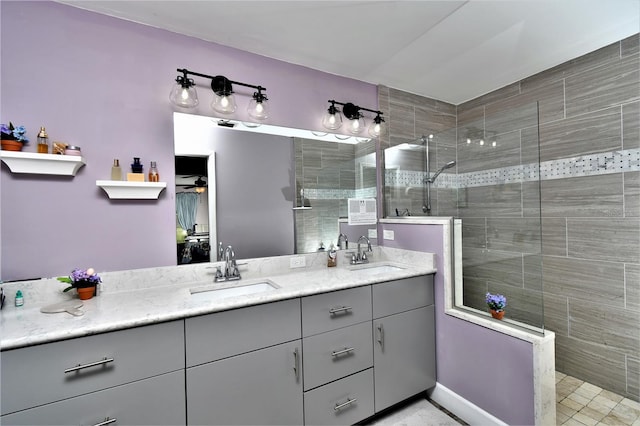 bathroom featuring a shower with shower door and double vanity